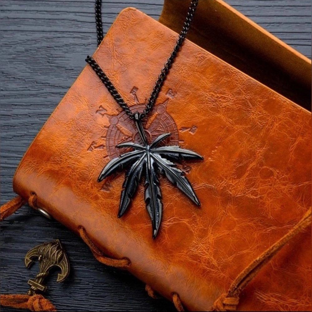 Black Leaf Pendant Necklace on Brown Leather Journal